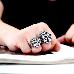 Detailed macro view of vintage flame skull rings in punk style on a hand model