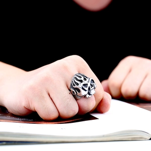 Detailed view of punk flame skull ring in vintage stainless steel worn by a model