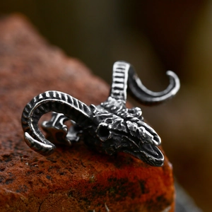 Vintage stainless steel ram skull pendant with aged finish and detailed horns on brick background