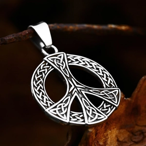 Vintage stainless steel peace sign pendant with intricate Celtic knot patterns on dark metal