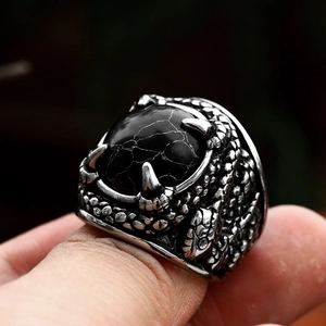 Macro shot of retro dragon claw ring with black turquoise stone and snake scale details