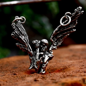 Vintage stainless steel wing pendant with character center on rustic brick background