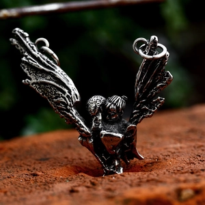 Gothic stainless steel pendant with detailed angel wings on a red brick texture background