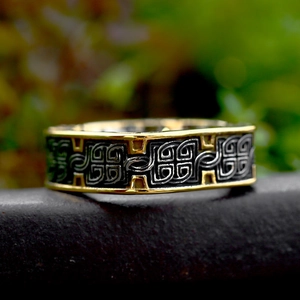 Vue macro de la bague en acier doré avec motif de nœud celtique noir et tressé