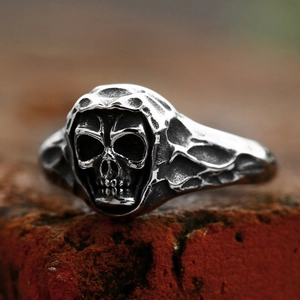 Vintage punk skull ring in oxidised stainless steel on a textured brick surface