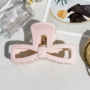Detailed view of large pink bow hair claw clip made of soft-touch resin for thick hair
