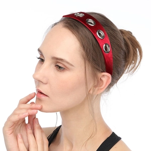 Serre-tête en satin rouge avec œillets métalliques argentés porté par un mannequin femme