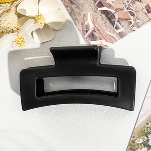 Detail of matte black square claw clip for hair with minimalist geometric hollow design