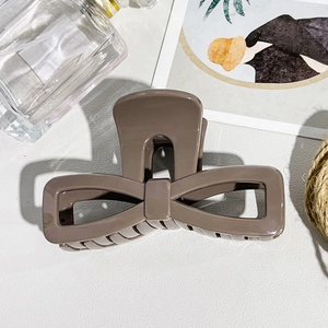 Close-up of a large mocha brown bow hair claw clip with sleek polished finish
