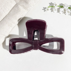 Detailed view of dark purple UV-painted bow hair claw clip with a glossy mirror finish
