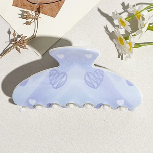 Detail of lavender gradient hair claw clip with white heart patterns and floral decor