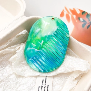 Détail d'un peigne ovale avec texture marbre vert et design de miroir intégré