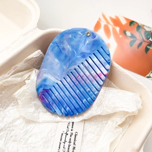 Vue détaillée du peigne en résine à motif marbré bleu et blanc avec trou de suspension