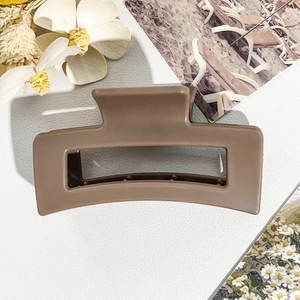 Detail view of 8.5cm matte coffee square hair claw clip on elegant white leather surface