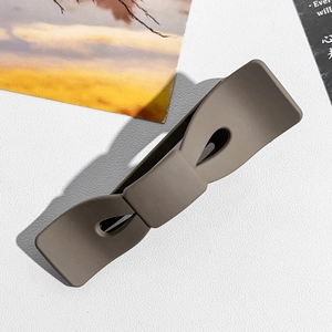 Vue détaillée d'une grande pince à cheveux marron foncé mate en forme de nœud élégant