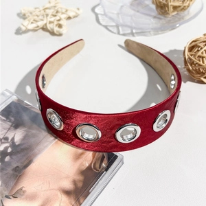 Détail du serre-tête en satin rouge avec œillets métalliques et doublure antidérapante