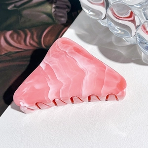 Detailansicht des rosa Marmormusters auf dieser dreieckigen UV-lackierten Haarklammer