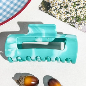 Detail of mint green marble textured rectangular shark hair claw clip for long hair