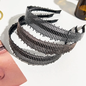 Gros plan de trois serre-têtes en strass étincelants en argent, or rose et noir