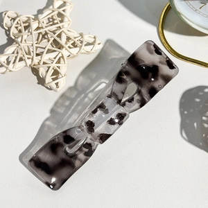 Dettaglio della texture in marmo bianco e nero sulla clip per capelli piatta ed elegante