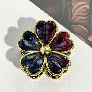 Detail of flower hair claw clip with purple resin petals and gold plated metal edges