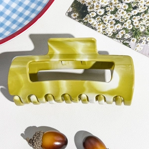 Close-up of marble pattern acetate hair claw clip with large rectangular hollow design