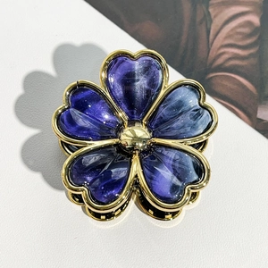 Detail of a purple flower claw clip with gold-plated edges and vintage resin texture