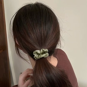 Chouchou plissé en satin vert olive porté en queue de cheval haute pour femme