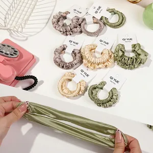 Chouchous en satin élastiques de couleurs variées montrés étirés pour la coiffure