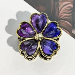 Detailed close-up of a golden flower hair claw with purple gradient resin petals