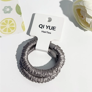 Détails de deux chouchous en satin gris sur carte de présentation pour coiffure élégante