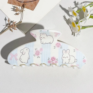 Detail of white semi-round hair claw clip with floral rose and cute bunny patterns