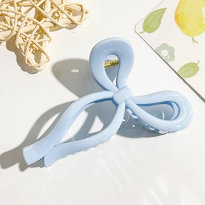 Light blue bow-shaped hair claw clip with glossy finish on a clean white background