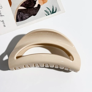 Detail showing creamy beige UV painted hair claw clip with smooth glossy finish