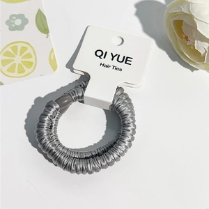 Détail d'un chouchou en satin gris avec cordon spirale élastique sur carte de support