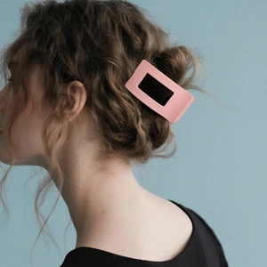 Pink matte square hair claw clip for women shown on light brown curly hair