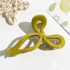 Close-up of olive green bow hair claw clip with glossy finish on white background