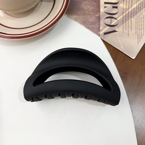 Detail view of large matte black shark hair claw clip with hollow semicircular design