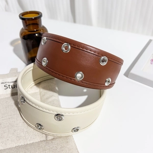 Detailed view of PU leather headbands with silver metal eyelet rivets in brown and beige
