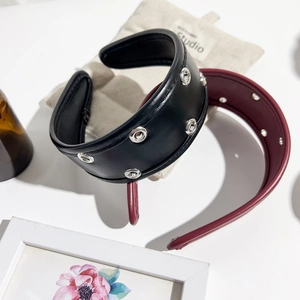 Detail of PU leather padded headbands with metallic eyelets in black and wine red tones