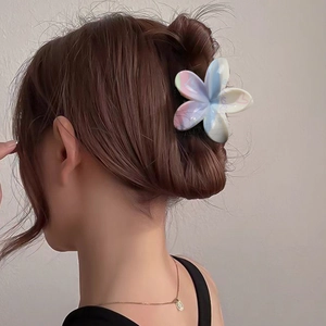 Frangipani claw clip with Lucky heart print worn in hair for beach vacation look