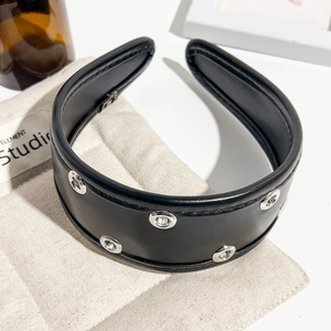 Detail of black PU leather headband with silver metal eyelets and thick padded structure