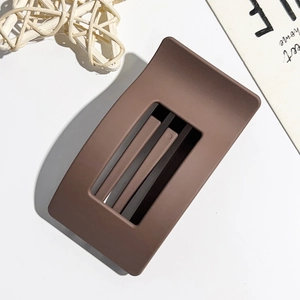Detailed view of deep brown matte rectangular hair claw clip on minimalist white background