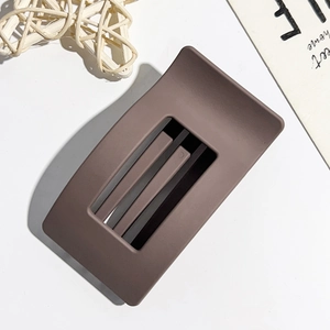 Detailed close-up of matte dark brown rectangular hair claw clip with internal comb teeth