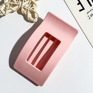Detail view of pink matte square hair claw clip with cutout geometric design and smooth finish
