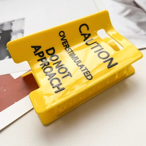 Yellow hair claw clip with Caution Overstimulated Do Not Approach print on white background