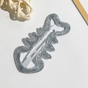 Dettaglio di un fermaglio per capelli ondulato glitter argento con design a stella vuota