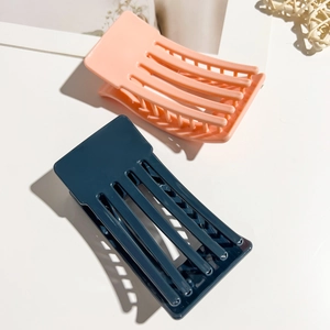 Close-up of 9.5cm square matte hair claws in peach and navy showing durable interlocking teeth