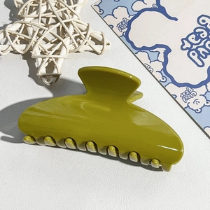 Detailed top view of a large olive green glossy hair claw clip on a white background