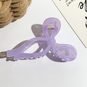 Détail d'une grande pince à cheveux violette en forme de nœud avec dents antidérapantes